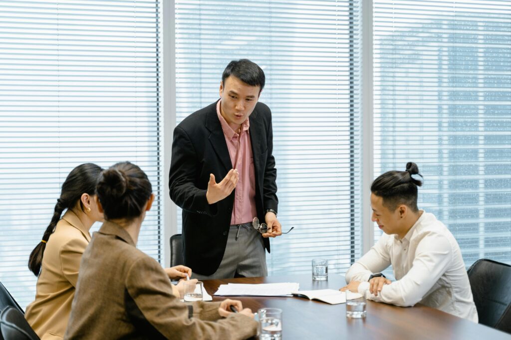 A sales manager coaching a group of representatives during a team strategy meeting.